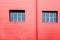 Red facade wall with two windows with reflection of sky. Copy space structure lines pattern. Industrial urban architecture look