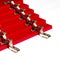 The red facades for the chest of drawers with metal loops lie on a white background. installation of furniture