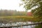 Red fall foliage in fog at Morey Pond, New Hampshire