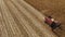 Red farm combine harvesting corn on an autumn day aerial view.