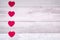 Red felt hearts on a background of old wooden planks resembling an old parquet floor. Concept of valentines day and love in