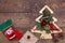 Red felt stocking and metallic golden fir tree with branches and cones, Christmas decorations, beads and gifts wrapped in paper on