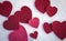 Red felt valentine hearts on the snow white background