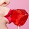 Red female lips shape lollipop. Close-up of woman lips kissing candy. Sweet tooth concept