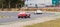 Red Ferrari 250 GT Berlinetta chasing  another white arriving at a curve in a classic car race at the Jarama circuit