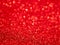 Red Festive Christmas background. Abstract twinkled bright background with bokeh defocused lights. Glister pattern. Brilliance