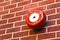 Red fire alarm on brick wall