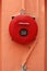 Red fire alarm on orange wall