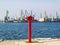 Red fire hydrant at the edge of the pier. The seaport on a sunny day. Fire safety and fire fighting at the sea port concept