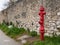 Red fire hydrant in front of a stone wall