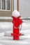Red fire hydrant on ground with a blanket of snow