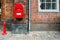 Red fire hydrant and red postal box against brick wall in Helsingor, Denmark