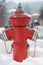 Red fire hydrant on the street. Fireplug in the snow