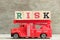 Red fire truck with ladder hold block word risk on wood background