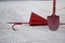 Red fireman scrap hook, spade, cone bucket shield against the background of sand