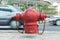 red fireplug standing alone on footpath/motion blur car background