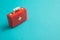 Red first aid bag suitcase toy on blue background with copy space. First aid kit, healthcare , medical