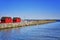 Red fisher houses behind the stone groyne at the harbor Weisse Wiek in Boltenhagen at the Baltic Sea. Germany