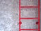 Red fixed ladder on cement wall