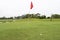 Red flag with Golfball on grass in golf course