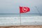 Red flag prohibiting swimming set on the sandy beach