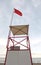 red flag symbol of danger in the turret on the beach