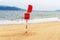 A red flag and a warning sign that it is forbidden to stay and swim on this beach. Ð¡losed beach due to measures to protect agains