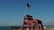 Red flag on a wooden rescue tower. Symbol of danger. A flag prohibiting swimming on the beach.