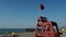 Red flag on a wooden rescue tower. Symbol of danger. A flag prohibiting swimming on the beach.