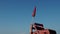 Red flag on a wooden rescue tower. Symbol of danger. A flag prohibiting swimming on the beach. Restrictions.