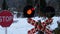 Red flashing traffic light at a railway crossing in a forest in winter. Train passing by