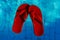 Red flip-flops floating in a swimming pool, a top view