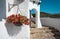 Red flowers hung on a white wall in the traditional fishing village of Binibeca on the coast of Menorca, Spain.