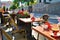 Red flowers, terrace on a sunny day, cafe tables outside.