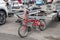 Red folding small wheeled bike leaning against an automotive trailer