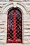 Red forged lattice on the arched window of an ancient building