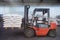 Red forklift lifts pallet with white bags