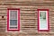 Red framed windows in log house wall architecture