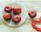 Red fresh apples on a plate, bright cloth on a wooden table, healthy food concept