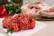 Red fresh minced meat on the background of lamb legs, red pepper and greens. Ground beef on the background of fresh meat in the