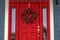 Red front door with wreath and glass panes in Utah