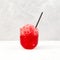 Red fruit iced drink. Granizado or Slushie - drink with natural juice. Fruit shaved ice in clear glass. Refreshing summer cocktail