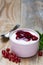 Red fruit jelly with currants in a bowl on wooden background