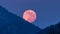 Red full moon is setting down over forest mountains in blue winter evening nature Time lapse