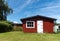 Red garden shed with white door on a sunny day