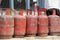 Red gas cylinders stand in a row near the house on the street.