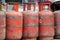 Red gas cylinders stand in a row on the street.