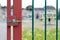 Red gate locked with playground in the background