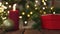 red gift box, candle, golden ball Christmas tree defocused lights wooden table