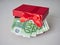 A red gift box filled with Euro currency money. Banknotes with a nominal value of 100 euros